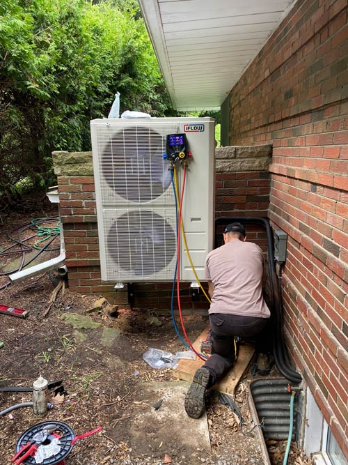 A technician working on an air conditioner A technician working on an air conditioner