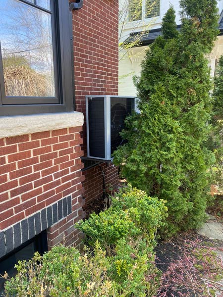 Exterior view of a brick house with a window AC unit installed Exterior view of a brick house with a window AC unit installed