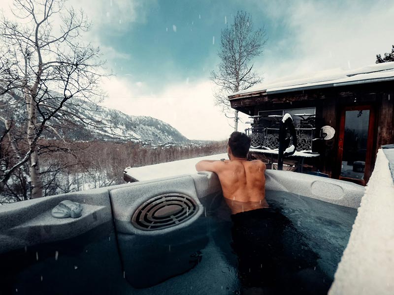 Man relaxing in an outdoor hot tub Man relaxing in an outdoor hot tub