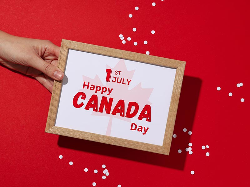 Hand holding a framed sign that reads 1st July Happy Canada Day Hand holding a framed sign that reads 1st July Happy Canada Day