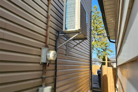 Air conditioner mounted on a brown house wall