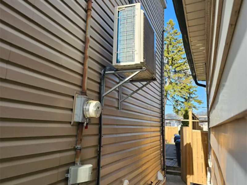 Air conditioner mounted on a brown house wall Air conditioner mounted on a brown house wall