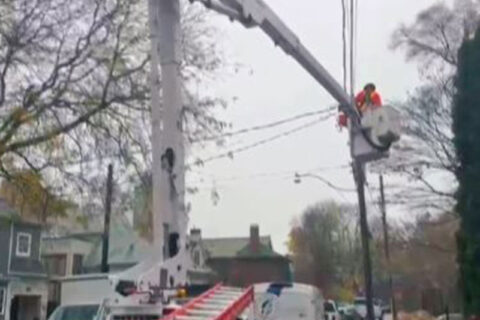 A bucket truck on the road fixing wires