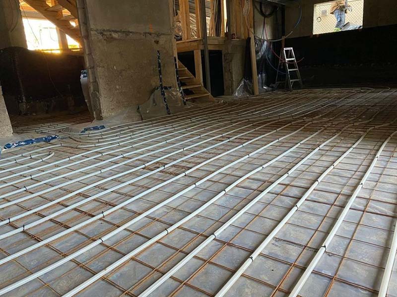 Indoor construction site with white piping laid out on floor Indoor construction site with white piping laid out on floor