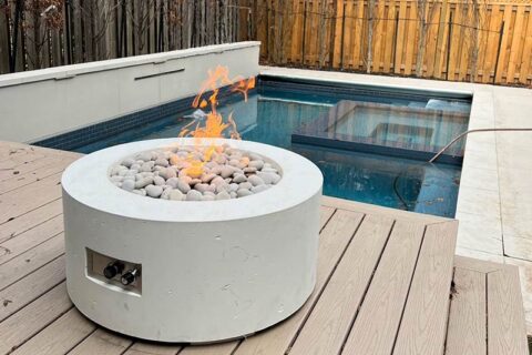 round fire pit with flames and stones